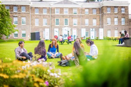 People sitting on grass in front of a building