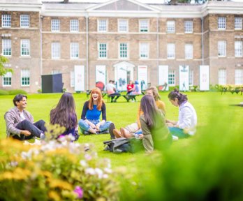 People sitting on grass in front of a building