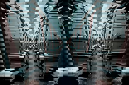 A view of a train aisle which splits rows of train seats in half