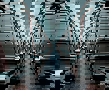 A view of a train aisle which splits rows of train seats in half 