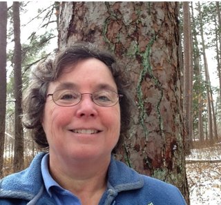 Headshot of person in snowy woods.