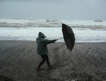 erson Holding Umbrella On Windy Beach