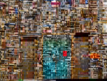 Huge piles of books surrounding an old blue door