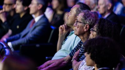People in a theatre room listening attentively.
