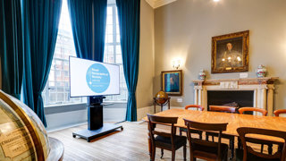 A grand council room with a plasma screen for presentations.