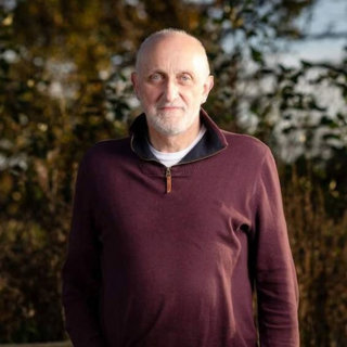 Geoff Carss standing infront of trees.