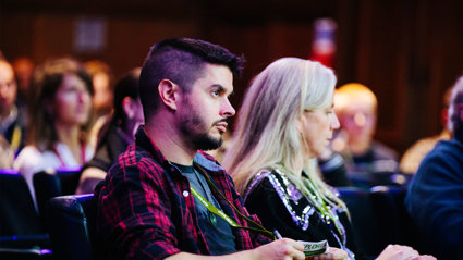 People sitting in an auditorium listening to a lecture.