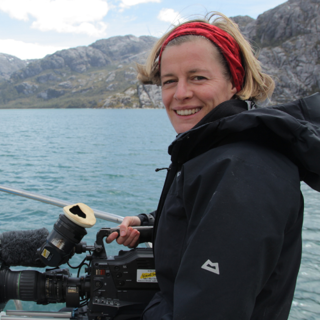 Person at sea holding camera equipment. 