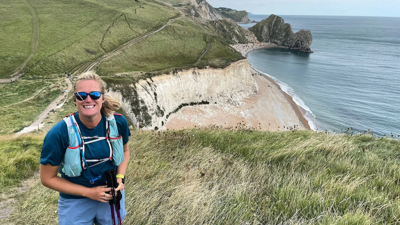 Helen standing on a coastal cliff path