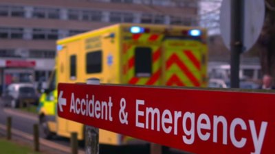 Accident and emergency sign outside a hospital with ambulance.