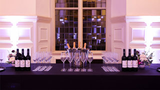 A bar with wine and champagne bottles set-up in a grand main hall.