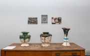 Three pots displayed on a wooden table.