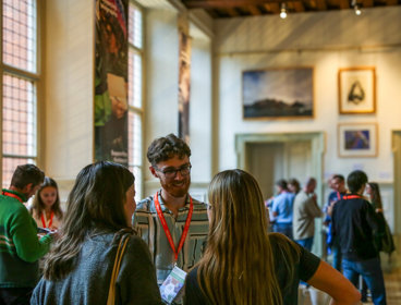Conference attendees networking in the Main Hall at the Royal Geographical Society.