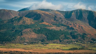 A view of a mountain range with clouds in the sky.