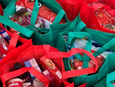 Cluster of shopping bags filled with groceries.