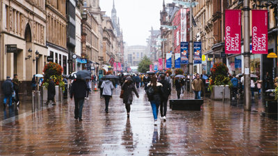 People walking down a street in Glasgow in the rain.