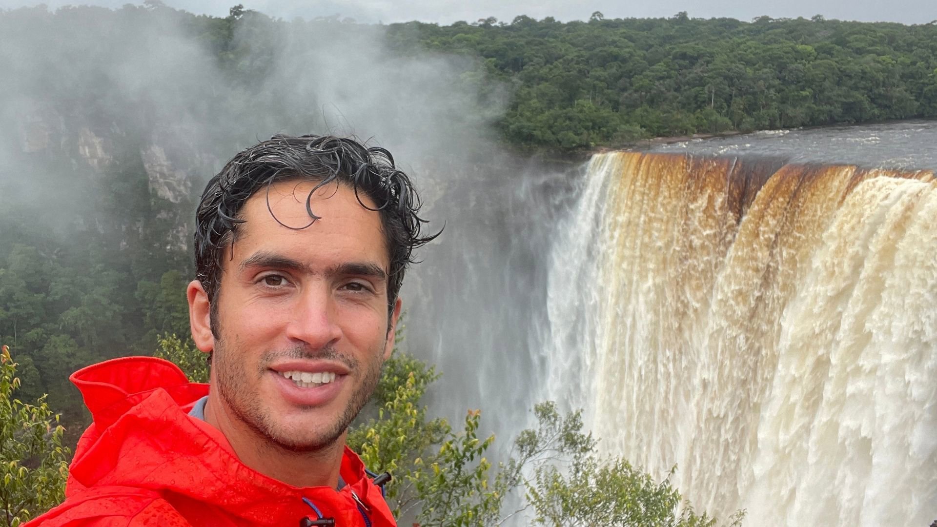 A person standing in front of a waterfall.