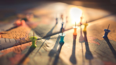 Upturned pins shown located on a map, bearing shadows.