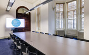 A small meeting room with a boardroom style set-up. 