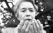 Person with worry-stricken face looking at their two hands.