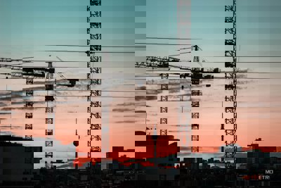 silhouette of crane trucks against a sunset