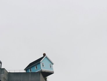 Blue house hanging on an edge.