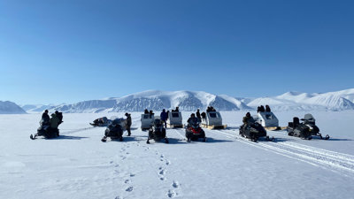 Group of people on snowmobiles in the Arctic. 