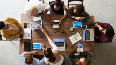 Aerial view of people working at laptops around a table.