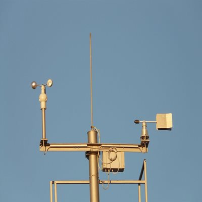 A gold anemometer on a blue sky background