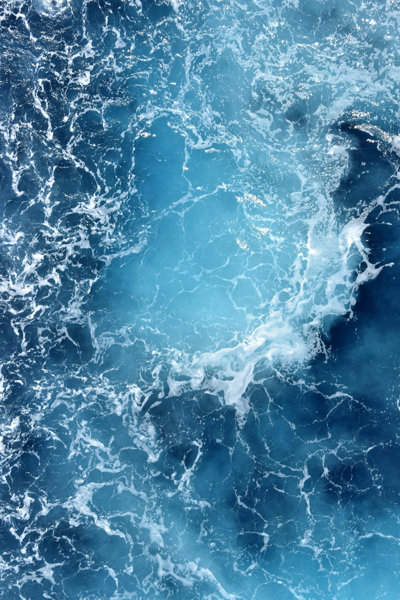 Sea viewed from above with white foamy waves