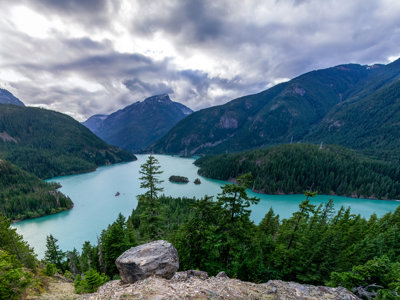 A view over a blue lake, located in the valley between mountains