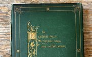 Green book on a brown table, with gold lettering