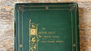 Green book on a brown table, with gold lettering