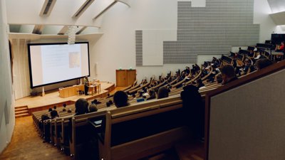 Tiered lecture theatre with speaker presenting at the front