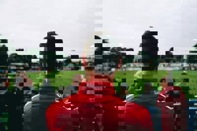 A man pictured from the back watching a football match