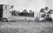 Black and white photograph showing Byzantine style buildings and palm trees.