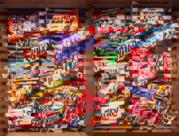 Variety of different brands of chocolate bars in a box.