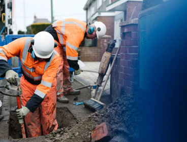 Construction worker digging hole into ground.