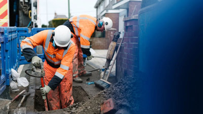Construction worker digging hole into ground.