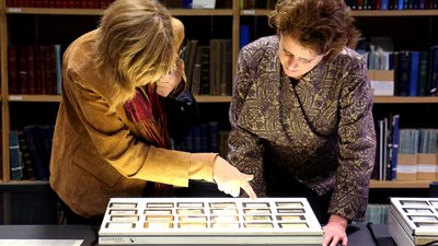 Two women looking down at images on a lightbox