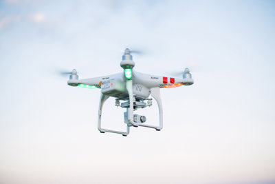 A white drone flying in the air