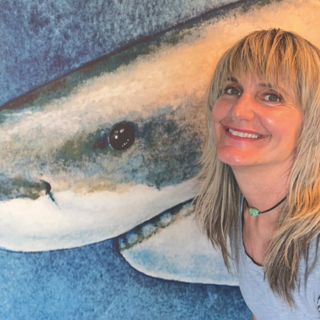Headshot of Kirsten Carlson next to shark artwork.