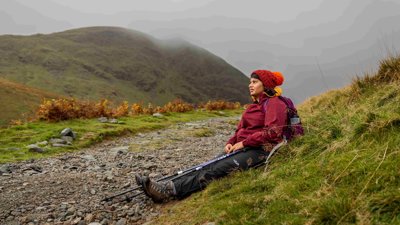Anisah Barber sat on a mountain path with fog in the background