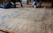 An old map on the floor. It is being looked by conservators