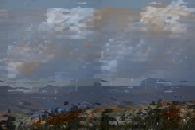 Five wind turbines in a mountainous landscape. 