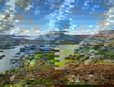 A view over the Lake District showing a lake, mountains and a town