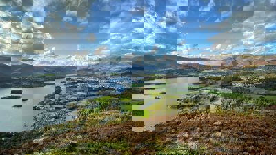 A view over the Lake District showing a lake, mountains and a town