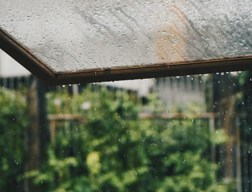 An open window exposing heavy rain outside.