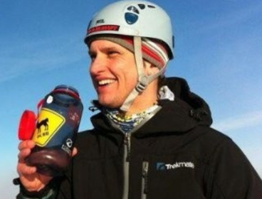 Headshot of Will Close Ash. He's wearing winter apparel, a helmet and is holding a refillable water bottle.