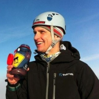 Headshot of Will Close Ash. He's wearing winter apparel, a helmet and is holding a refillable water bottle.